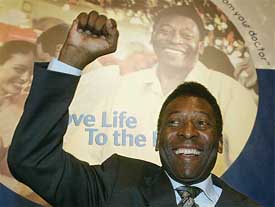 Brazilian soccer legend Pele raises his fist at a Pfizer news conference in Brussels