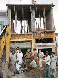 Shopkeepers block the JCB machine and stop the demolition squad in its tracks