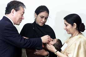 Union Health Minister Sushma Swaraj holds a child who's given polio drops by World Health Organisation Director General Lee Jong-Wook