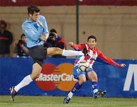 Uruguay's Cristian Gonzalez fights for the ball with Jorge Campos of Paraguay 