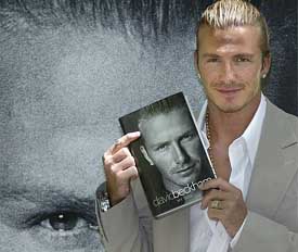 Real Madrid's English soccer player David Beckham poses with his autobiography