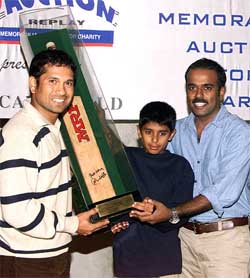 Sachin Tendulkar presents his auctioned bat to highest bidders Venu Nambiar and Kiran Kattukaran