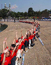 People fall over one another to form a human domino chain stretching five kilometers at a tourist resort in Changsha