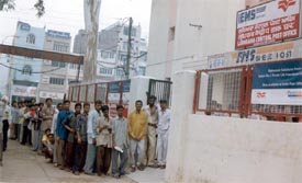 A long queue of migrants outside the Mata Rani Chowk post office 