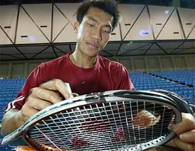 Asia's top tennis player Paradorn Srichapan cleans a racket before practice in Bangkok 