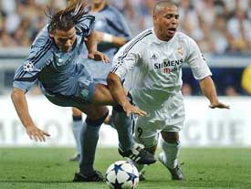 Real Madrid�s Brazilian striker Ronaldo is tackled by Marseille�s Daniel Van Buyten 