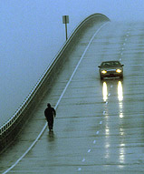 North Carolina State Troopers closely follow an unidentified pedestrian as he crosses the Atlantic Beach-Morehead City Bridge in high winds from Hurricane Isabel in Morehead City
