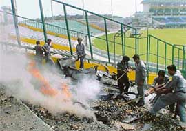 Workmen on duty at the PCA Stadium in SAS Nagar engaged in clearing the remains of the stadium scoreboard which was destroyed in a fire on Saturday
