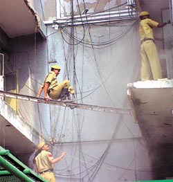 Firemen clamber to safety at the Police Headquarters in the Capital