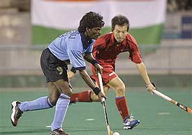 India's Dhanraj Pillay tries to get past China's Jiang Xi Shang 