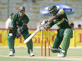 Pakistani batsman Yasir Hameed plays a shot to reach his fifty as Bangladesh wicketkeeper Khaled Mashud looks on