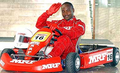 West Indies cricket captain Brian Lara waves to photographers at the inauguration of the MRF-mai Go-Karting championship in Kolkata