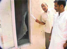 Mr Stevon Soni shows the wire mesh of a window that was cut by robbers in his house