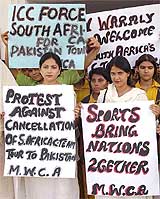 Female cricket fans hold placards to protest the cancellation of South African cricket team's tour to Pakistan, in Multan