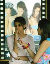 Cinemagoers stand in front of a movie poster