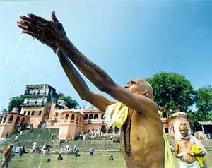 An elderly man offers holy water and prayers