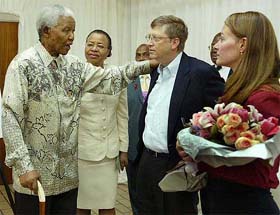 Former South African President Nelson Mandela and his wife Graca Machel talk to Bill and Melinda Gates