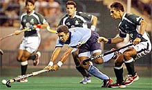 Deepak Thakur (C) tries to control the ball as he is challenged by Pakistan’s Rehan Butt