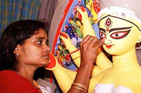 China Paul, the only female artist of Kumartuli, the hub of idol makers in the city, gives finishing touches to one of her idols in Kolkata