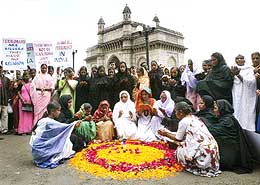 Women offer prayers at the site of last month's twin bomb blasts outside the Gateway of India monument in Mumbai