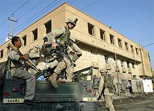 US soldiers arrive in front of the hotel which was affected by a bomb blast in Baghdad