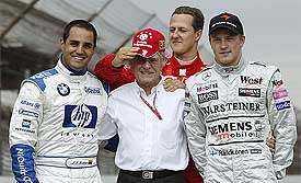 Ferrari driver Michael Schumacher of Germany puts his hat on the head of Formula 1 chief Bernie Ecclestone