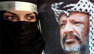 A Palestinian student holds a poster of Palestinian President Yasser Arafat 