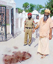 Mahant Dhan Raj Gir shows the pool of blood of a robber who was killed in a police encounter at Dera Gusiyan at Kurali on Saturday night.