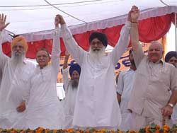 Former Punjab Chief Minister Parkash Singh Badal exhibits solidarity with Mr I.D. Swami, Minister of State for Home, and Mr Chaman Lal Gupta, Minister of State for Defence, at a political conference at Serai Amanat Khan in Amritsar 