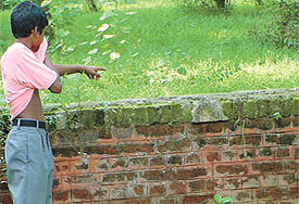 A boy points out the spot where the decomposed body of a naked woman was found 