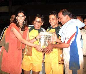 Former Miss Universe Yukta Mukhi hands over the winner's trophy to Madhya Pradesh Chief Minister and CM XI captain Digvijay Singh 
