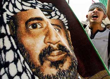 A boy, holding a poster of Palestinian President Yasser Arafat, chants anti-Israeli slogans at a rally to mark the third anniversary of Intifada