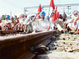 Agitators squat on a railway track as part of their statewide protest against government policies