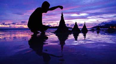 A tourist build sandcastles on Chenang Beach