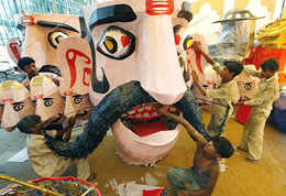 Artists give finishing touches to an effigy of Ravana