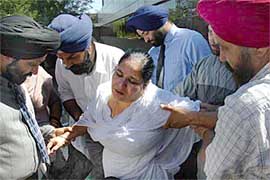 Harjinder Kaur Sodhi, wife of hate crime victim Balbir Singh, is helped up after she collapsed outside Maricopa County Court in Mesa, Arizona, on Tuesday, where Frank Roque was found guilty of the September, 2001, murder