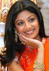 Shilpa Shetty models gold jewellery, while posing for photographers, after inaugurating a jewellery store in New Delhi