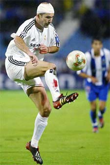 Real Madrid's Zinedine Zidane wears a bandage on his head after sustaining a cut as he controls the ball 