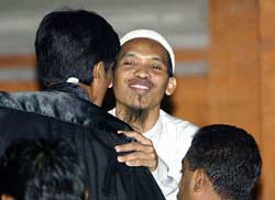 Mukhlas hugs his lawyer just moments before receiving a death sentence