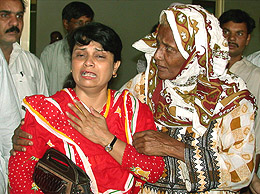 A relative comforts a woman after two gunmen attacked a bus carrying Shia Muslim worshippers  in Karachi on Friday, killing five persons.