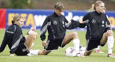 Germany's Sonja Fuss Sandra Smisek and Nia Kunzer stretch during a training session