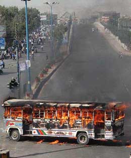 A bus burns after mourners went on the rampage