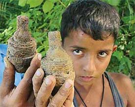 Sohal Lal (8) of Mandlai village shows unexploded shells he unearthed from a field near the Army firing range near the village. 