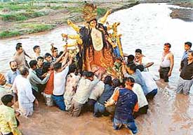 An idol of Goddess Durga being immersed in the Ghaggar near Chandigarh on