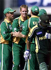 Shaun Pollock of South Africa is greeted by teammates after he dismissed Pakistan's Mohammad Hafeez