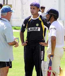 Indian cricket team captain Saurav Ganguly and star cricketer Sachin Tendulkar speak with coach John Wright