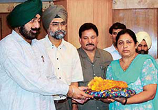 Mrs Gurmeet Kaur, mother of ace hockey player Jugraj Singh, receives a cheque of Rs 5 lakh from Mr Jagmohan Singh Kang, Sports Minister, Punjab, on Monday.