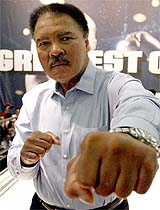 Former heavyweight world champion Mohammad Ali jabs during the presentation of his book