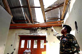 An Amy officer shows the roof of a school building