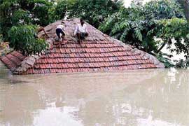 People take shelter on the roof of a house